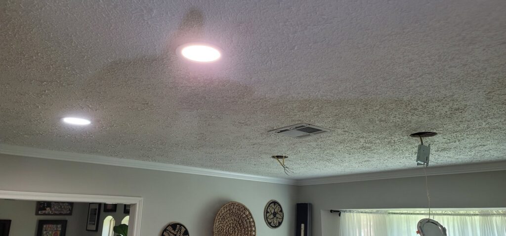 A ceiling showing installed recessed lights and an opening for a new fixture, handled by Ponce Electric in Houston, TX