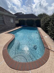 A clean, rectangular swimming pool with an automatic pool cleaner visible in the water, maintained by La Pool Pro LLC in New Orleans, LA.