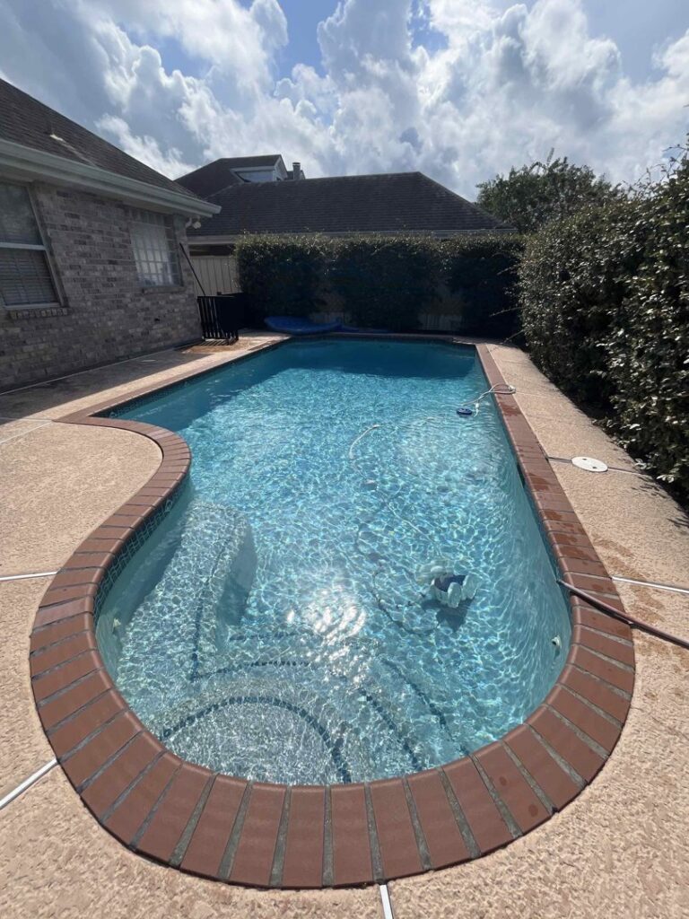 A clean, rectangular swimming pool with an automatic pool cleaner visible in the water, maintained by La Pool Pro LLC in New Orleans, LA.
