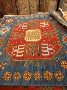 A close-up of a vibrant red and blue geometric tribal rug, part of the collection at Yayla Tribal Rugs, Inc. in Cambridge, MA.