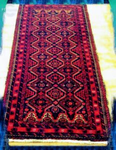A vibrant red and black patterned rug runner, demonstrating the variety of rugs handled by N J Green Rug Cleaning in Jersey City, NJ.