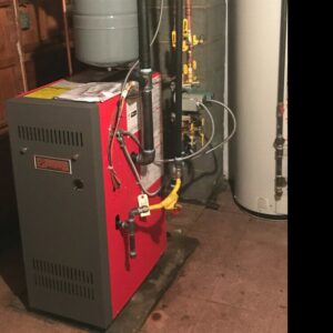 A red boiler or furnace unit installed in a basement by Accurate Conditioning in Sayreville, NJ.
