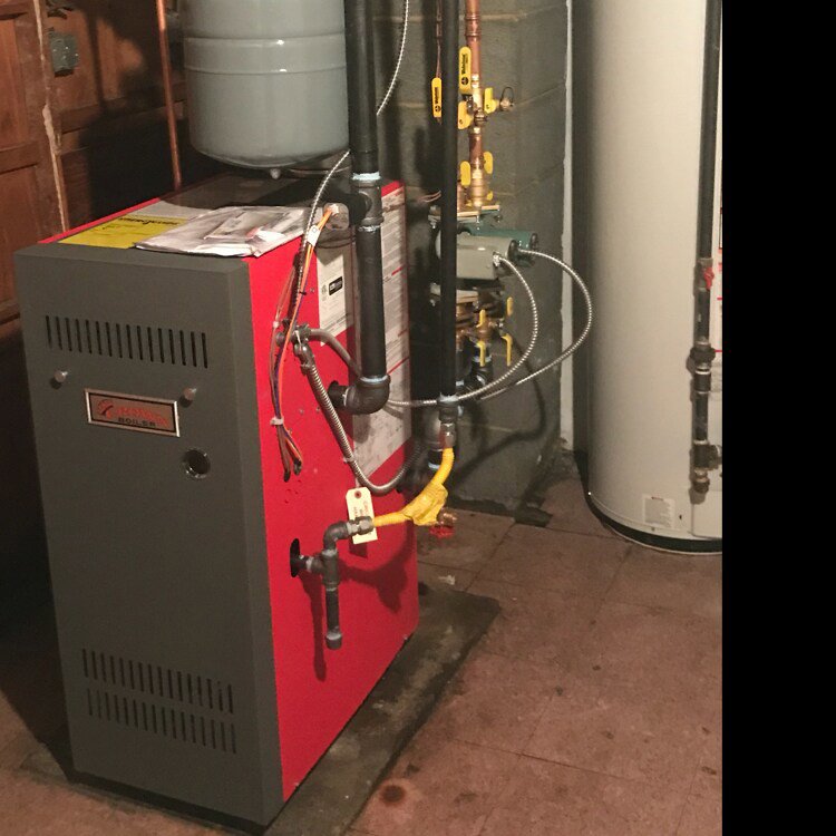 A red boiler or furnace unit installed in a basement by Accurate Conditioning in Sayreville, NJ.