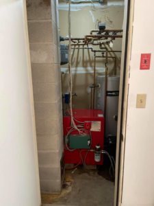 A red boiler and water heater system installed by Aaron Hamilton Heating in Brunswick, ME.