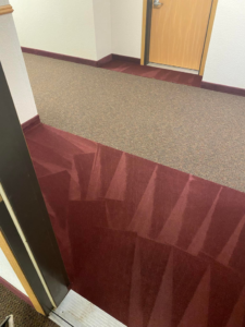 A clear transition between freshly serviced red and brown carpets in a commercial space by Agwa's carpet core in Minneapolis, MN.