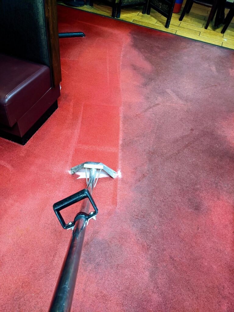 A professional carpet cleaning wand cleaning a red carpet, showing the difference by Inspection Ready LLC in Bellevue, NE.