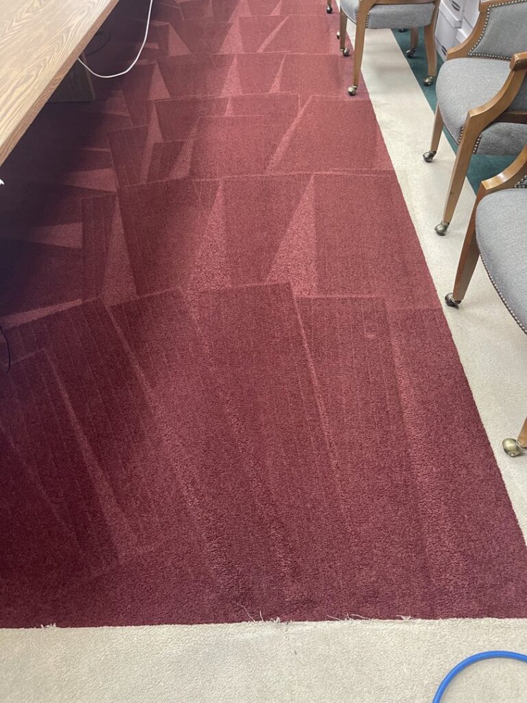 A red carpeted area showing distinct cleaning lines after service by Jones Carpet Care LLC in Huntsville, AL.