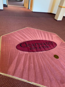 A large red carpet area with a custom 'Clearwater Estates' logo mat, demonstrating carpet services by Agwa's carpet core in Minneapolis, MN.