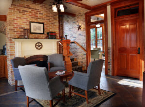 A beautifully installed red carpet runner on a grand wooden staircase by O'Hanlon Home Services in Austin, TX.