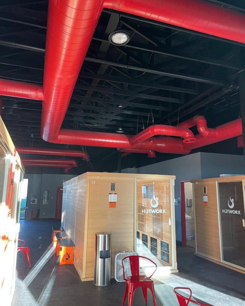 Red exposed commercial ductwork installation in a facility by Big Leaf Mechanical LLC, an HVAC contractor in South Salt Lake, UT.