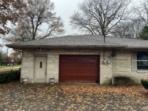 A red garage door installed on a stone house by Precision Garage Door of Owensboro Evansville in Owensboro, KY.