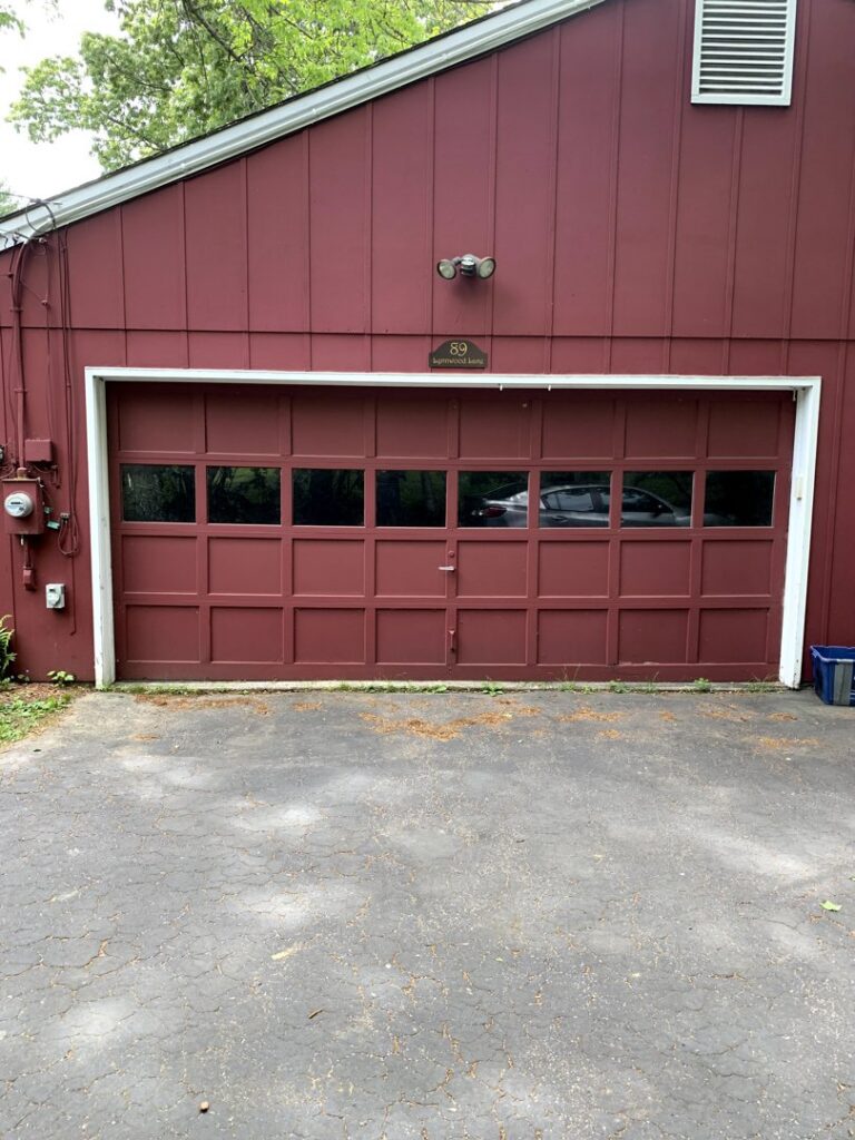 A red garage door with top windows installed by Snowbird Garage Doors Company in Worcester, MA.