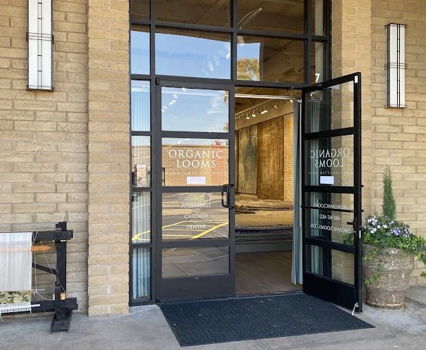 A vibrant red rug with bold geometric patterns and decorative fringes, available at Organic Looms in Scottsdale, AZ