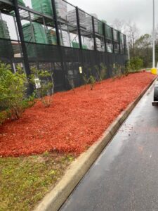 A large, vibrant red mulch bed installed as part of landscaping by L&L Lawn Care Service in Dothan, AL.