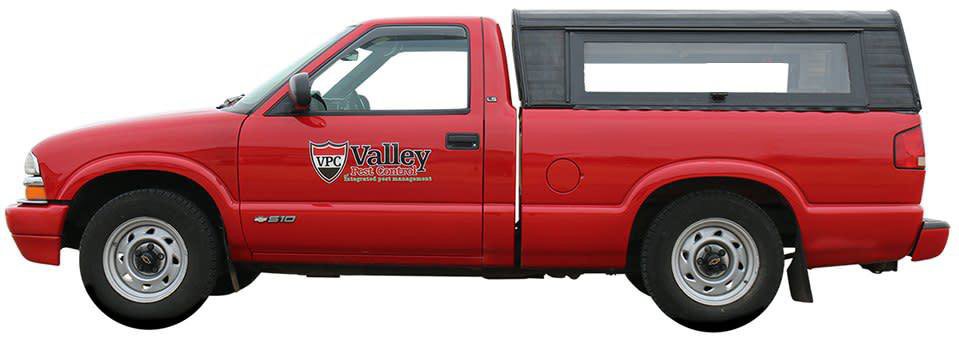 A red pest control truck with the Valley Pest Control logo, ready for service in Oshkosh, WI.