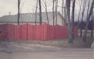 A newly installed red-stained wooden privacy fence by James Fencing LLC in Columbia, MO.