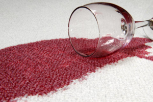 A red wine spill on a white carpet, demonstrating a common stain removal challenge for Good Clean Carpets in Atlanta, GA.