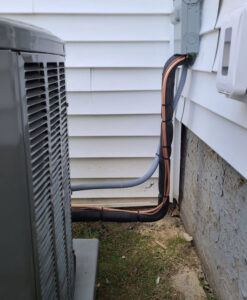 Close-up of insulated refrigerant lines connecting to an outdoor air conditioning unit by Allied Heating and Air Conditioning in Port Richey, FL.