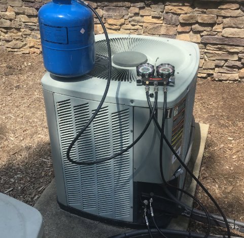 A refrigerant tank connected to an outdoor AC unit with gauges for RESTQ HVAC Repairs & Services in Rockville, MD.