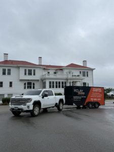A white pickup truck towing a branded Relay Electric, LLC service trailer in Suffolk, VA, ready for electrical and lighting jobs.
