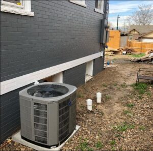 A residential air conditioning condenser unit installed outside a home by CHAMPS Heating&Air in Denver, CO