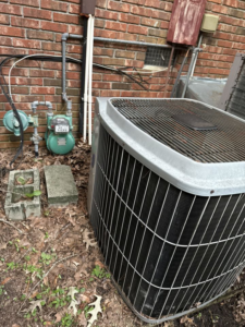 A residential outdoor AC unit with a gas meter nearby, maintained by Kirk Heating & Air Conditioning in Summerville, SC.