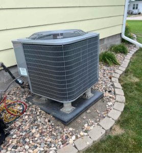 A residential air conditioning unit recently installed outside a home by Island Heating & Air in Grand Island, NE