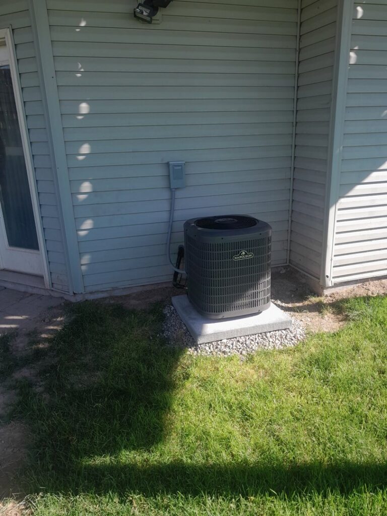 A new residential air conditioning unit installed outside a home, provided by Ridgeline Heating and Cooling in Idaho Falls, ID.