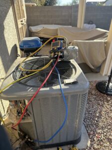 A residential AC unit undergoing a refrigerant check with gauges by Gotham Air LLC in Glendale, AZ.