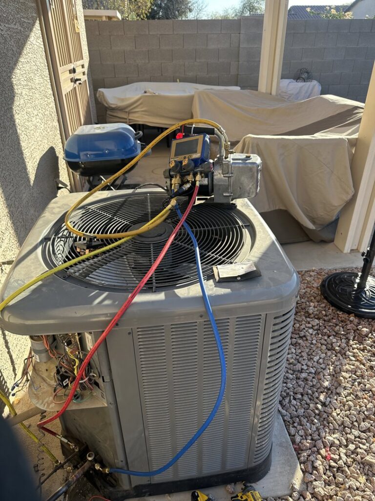 A residential AC unit undergoing a refrigerant check with gauges by Gotham Air LLC in Glendale, AZ.
