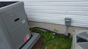 A residential outdoor AC unit showing refrigerant lines, serviced by Absolute HVAC in Wilmington, DE.