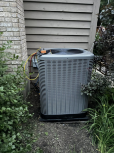 A residential AC unit undergoing repair with gauges connected by Four Stages, an HVAC contractor in Chicago, IL.
