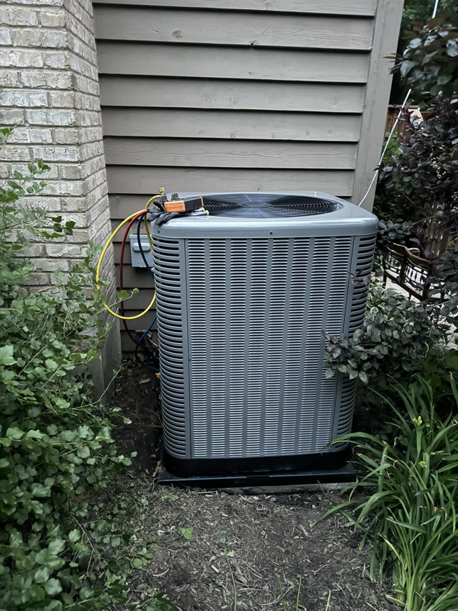 A residential AC unit undergoing repair with gauges connected by Four Stages, an HVAC contractor in Chicago, IL.