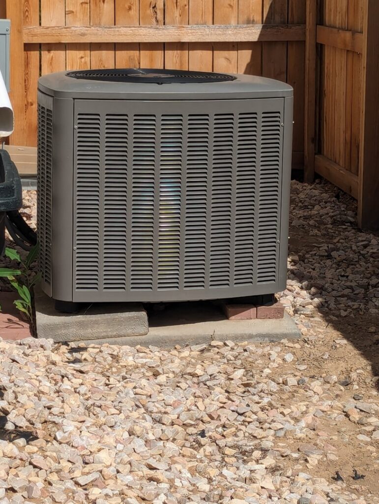 A residential outdoor air conditioning unit installed on a gravel bed by Thin Air Heating and Cooling in Arvada, CO.