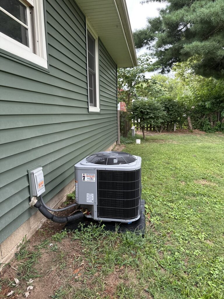 A residential air conditioner unit installed outside a home by Swiss Air Heating & Cooling in O'Fallon, MO.