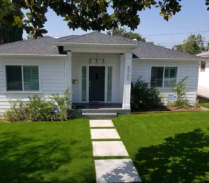 A beautifully installed artificial turf lawn in a residential front yard by Jabara's Turf Outlet in Wichita, KS.