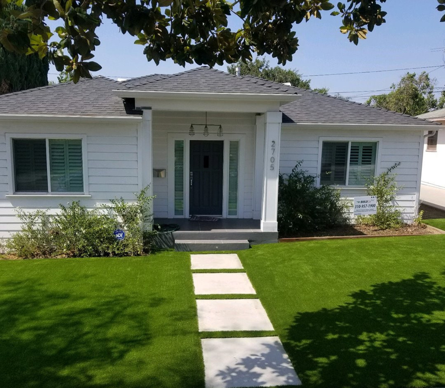 A beautifully installed artificial turf lawn in a residential front yard by Jabara's Turf Outlet in Wichita, KS.