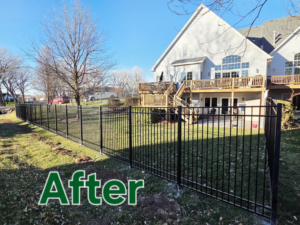 A completed black metal fence enclosing a residential backyard, installed by Green Acres Fence Co in Salina, KS.