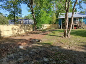 A newly installed wood fence defining the perimeter of a residential backyard by FenceCo LLC in Pass Christian, MS.