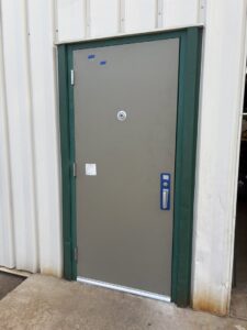 Two residential beige garage doors with decorative trim installed by Ozarks Overhead Door & More in Springfield, MO.