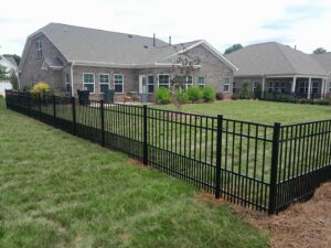 A sleek black aluminum fence enclosing a residential backyard, installed by Aguilarfence services LLC in Clayton, NC.
