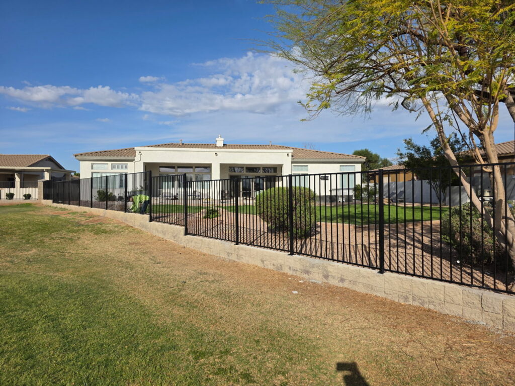 A residential black metal fence installed around a backyard by Competitive Fence Contractors LLC in Scottsdale, AZ.