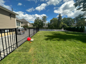 Residential black metal fence installed around a backyard and pool area by Fenced Up, LLC in Ravena, NY.