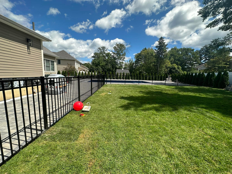 Residential black metal fence installed around a backyard and pool area by Fenced Up, LLC in Ravena, NY.
