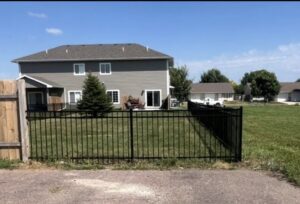 A black ornamental metal fence installed around a residential property by The GateKeeper Perimeter Fence & Automated Security in Sioux Falls, SD