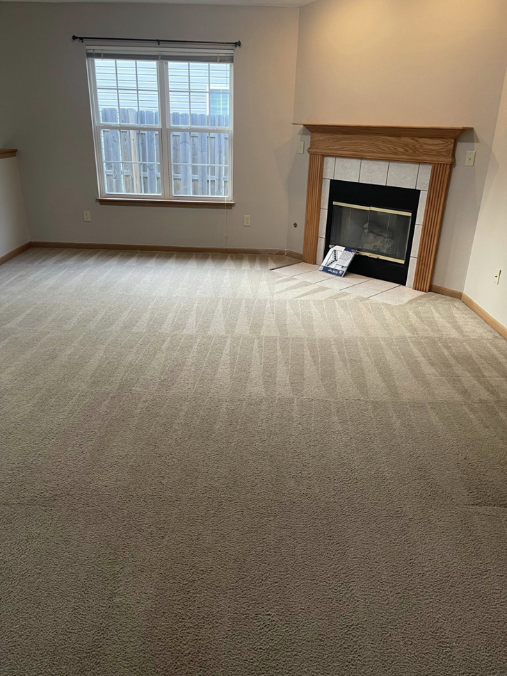 Clean carpet with fresh vacuum lines in a residential living room with a fireplace by Fox Cleaning Services in Lafayette, IN.