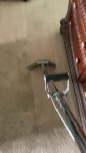 Residential carpet cleaning in progress, with a cleaning wand revealing a fresh path on the carpet by Koky's Carpet Cleaning in Bakersfield, CA