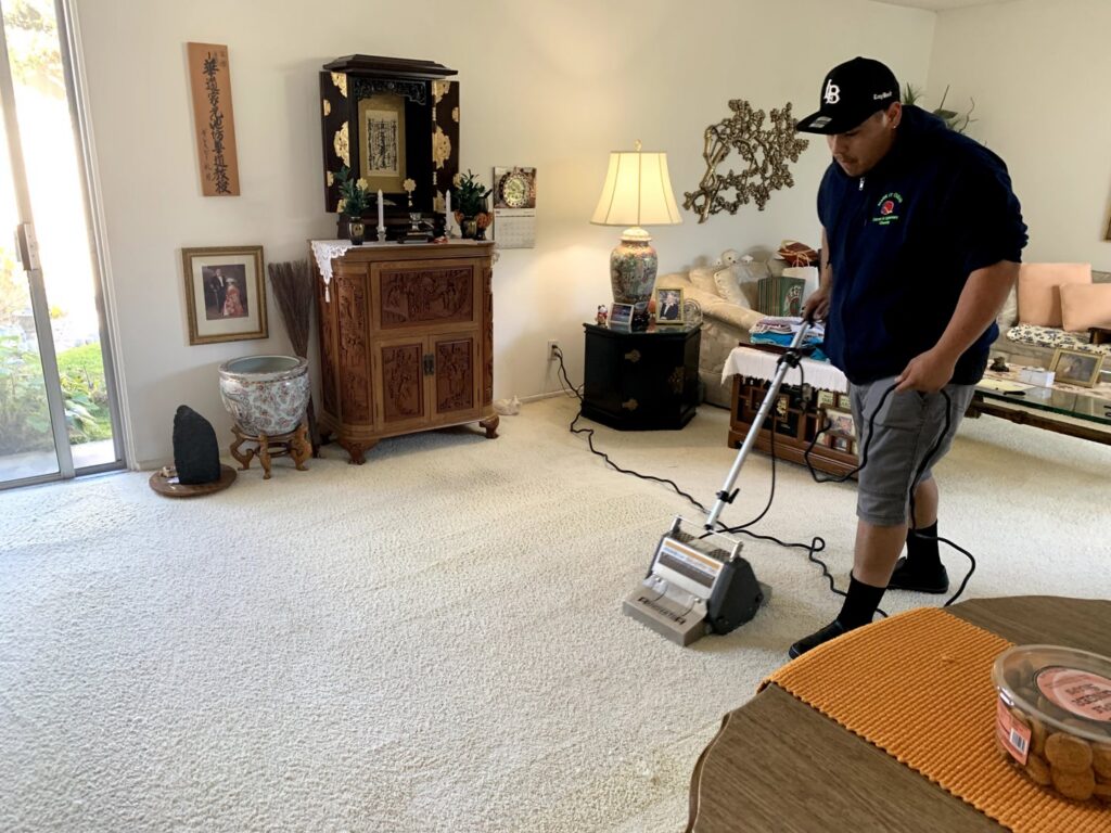 A professional performing residential carpet cleaning in a living room with a machine by Mark it Clean Carpet & Upholstery Cleaning Long Beach, CA.
