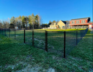 A black chain-link fence with a double gate enclosing a residential backyard, a project by Vision One Construction LLC in Schenectady, NY