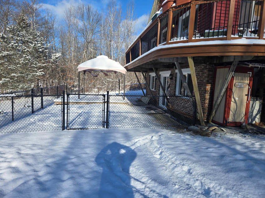 Residential chain link fence installation around a property in winter by Dore's Fence Company in Greenbush, ME.